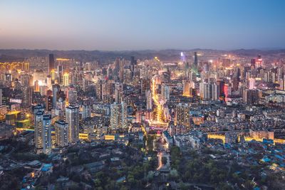 Illuminated cityscape against sky at night