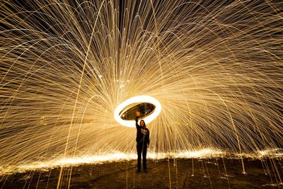 Full length of man with umbrella standing at night