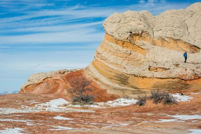 Man walks through fantastical rock formation at white pocket az