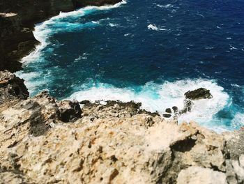 High angle view of rocks in sea against sky