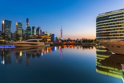 Reflection of buildings in city at waterfront