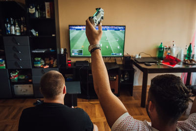 Friends playing video game at home