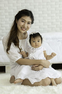 Portrait of mother and cute daughter at home