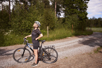 Female cyclist relaxing near bicycle