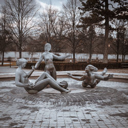 Statue against bare trees in park