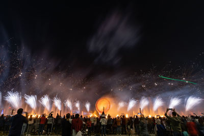 People watching fireworks at night