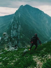 People hiking on grass mountain