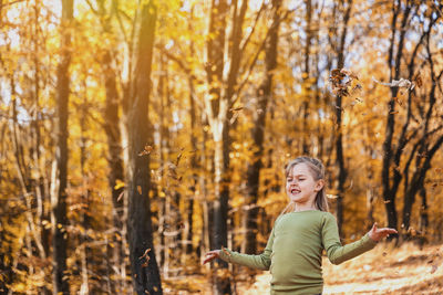 Portrait of young woman standing in forest