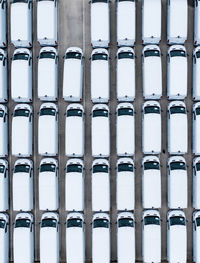 Aerial view of rows of new white vans stockpile on a manufacturers production line