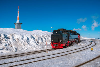 Train on railroad track against blue sky