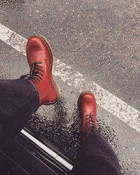 Low section of man standing on road