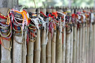 Close-up of colorful strings tied on wooden posts