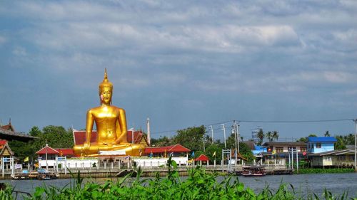 Statue of temple against building and sky