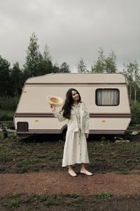 Full length of woman standing on field against sky