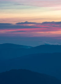 Scenic view of silhouette mountains against romantic sky at sunset