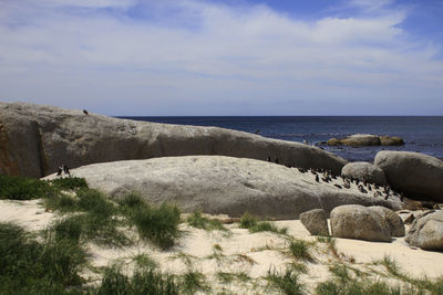 Rocks by sea against sky