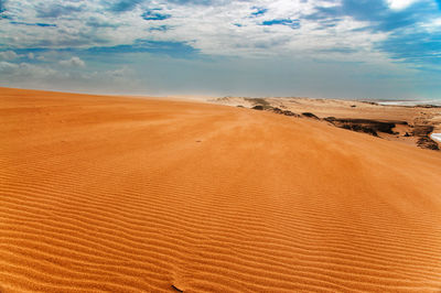 Sand dunes in desert against sky