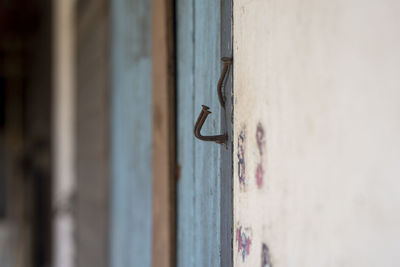 Close-up of rusty metal door against wall