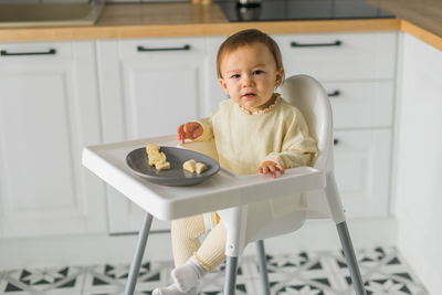 Portrait of cute baby boy sitting at home