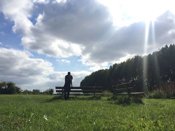 Silhouette man standing on field against sky