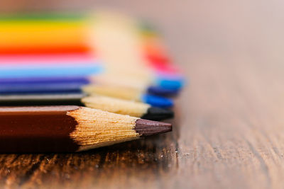 Close-up of colored pencils on wooden table