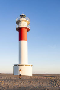 Full length of boy standing against lighthouse