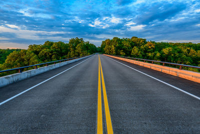 Surface level of empty road against trees