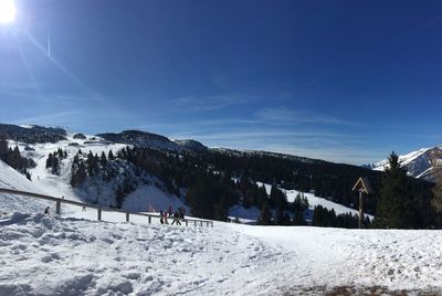 People on snowcapped mountain against sky