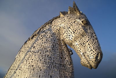 Low angle view of horse sculpture against sky