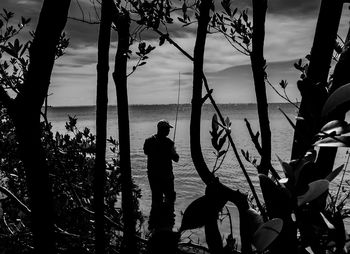 Rear view of man fishing in sea