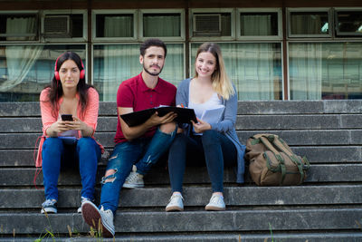 Portrait of friends sitting on staircase