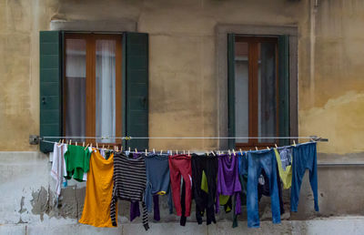 Clothes drying on clothesline by window