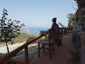 Man on built structure against clear sky