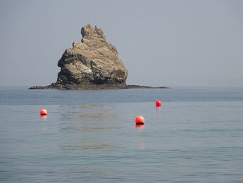 Red floating on sea against sky