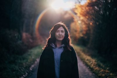 Portrait of woman standing against trees