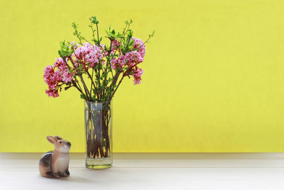 Flower vase on table against wall