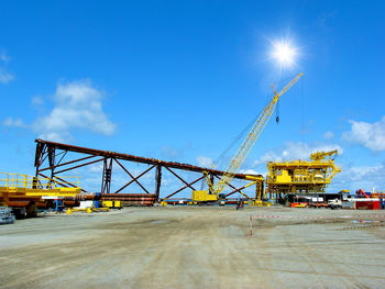 Cranes at construction site against sky