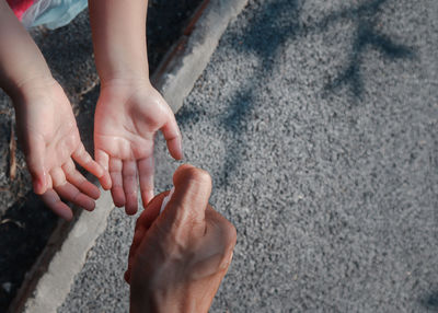 High angle view of hands holding baby feet