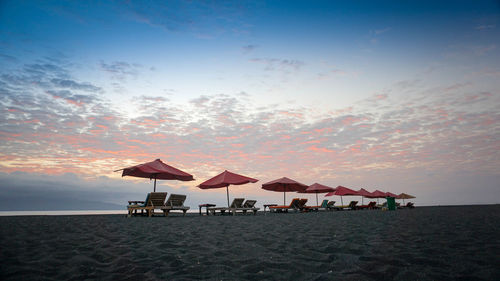 Lifeguard hut on beach against sky during sunset