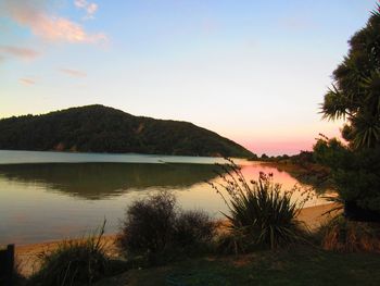 Scenic view of lake against sky at sunset