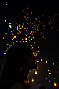 Portrait of young woman looking away at night