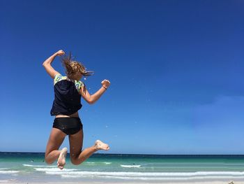 Full length of woman on sea against clear blue sky