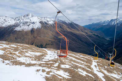 Mountain landscape with chairs of a single-seat cable car for lifting tourists, skiers and climbers
