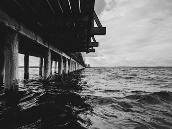 View of pier on beach against sky