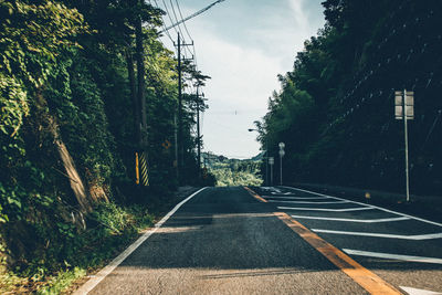 Road amidst trees against sky