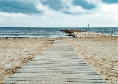 Scenic view of beach and wooden walkway