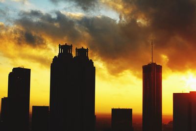 Silhouette city against sky during sunset