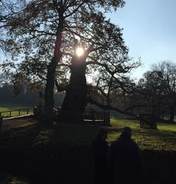 Silhouette people in park against sky