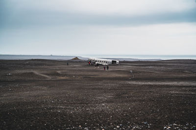 Scenic view of people on land against sky