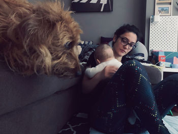Young man with dog sitting at home